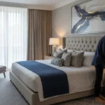 Få hotellkänsla hemma En person inreder ett rum med noggrant utvalda detaljer för att efterlikna en lyxig hotellsvit.